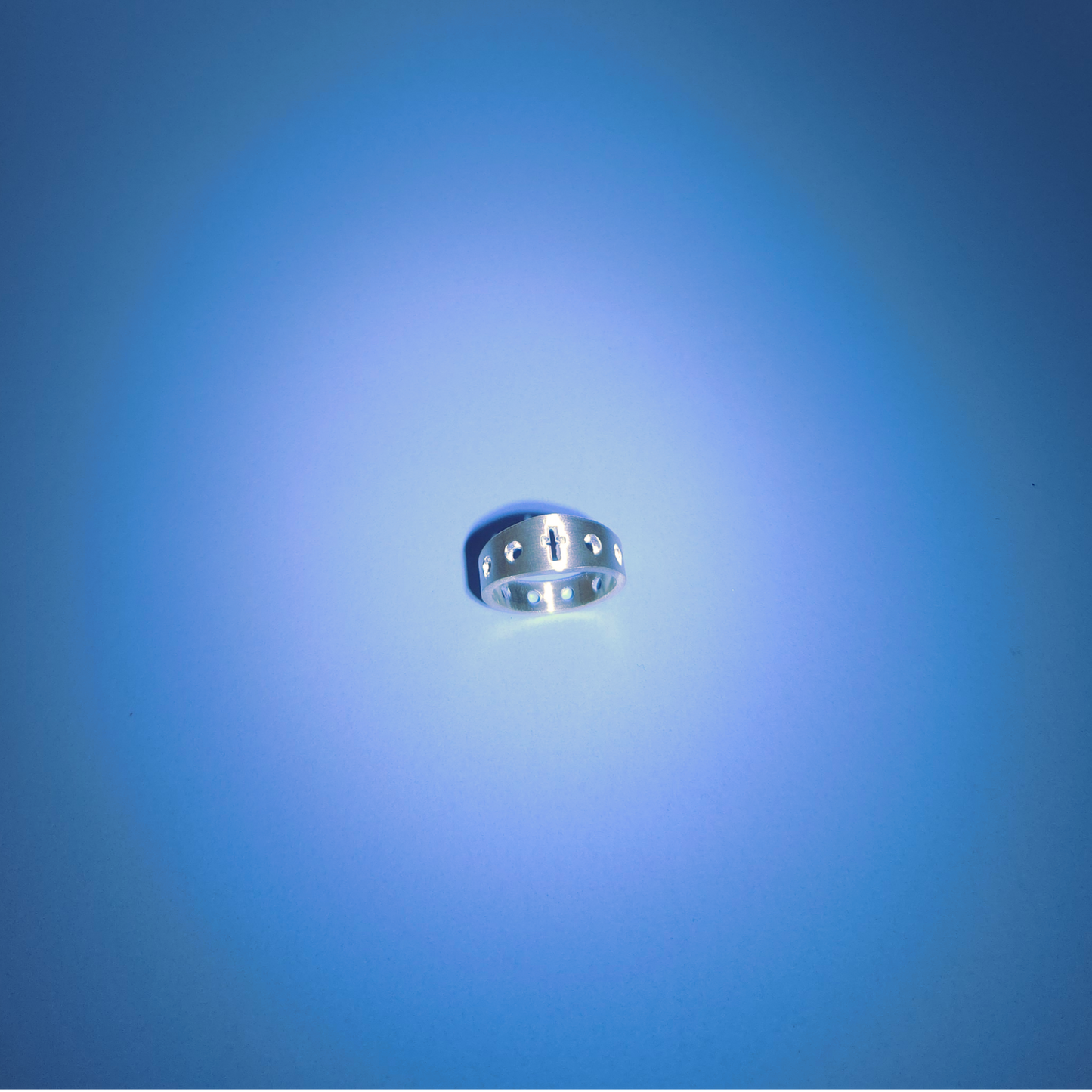 Silver rosary ring on a light blue background