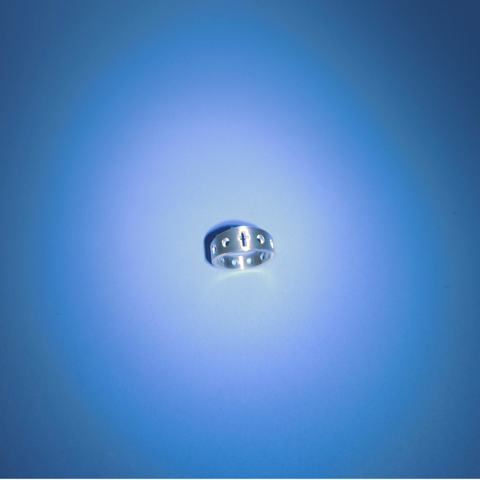 Silver rosary ring on a light blue background