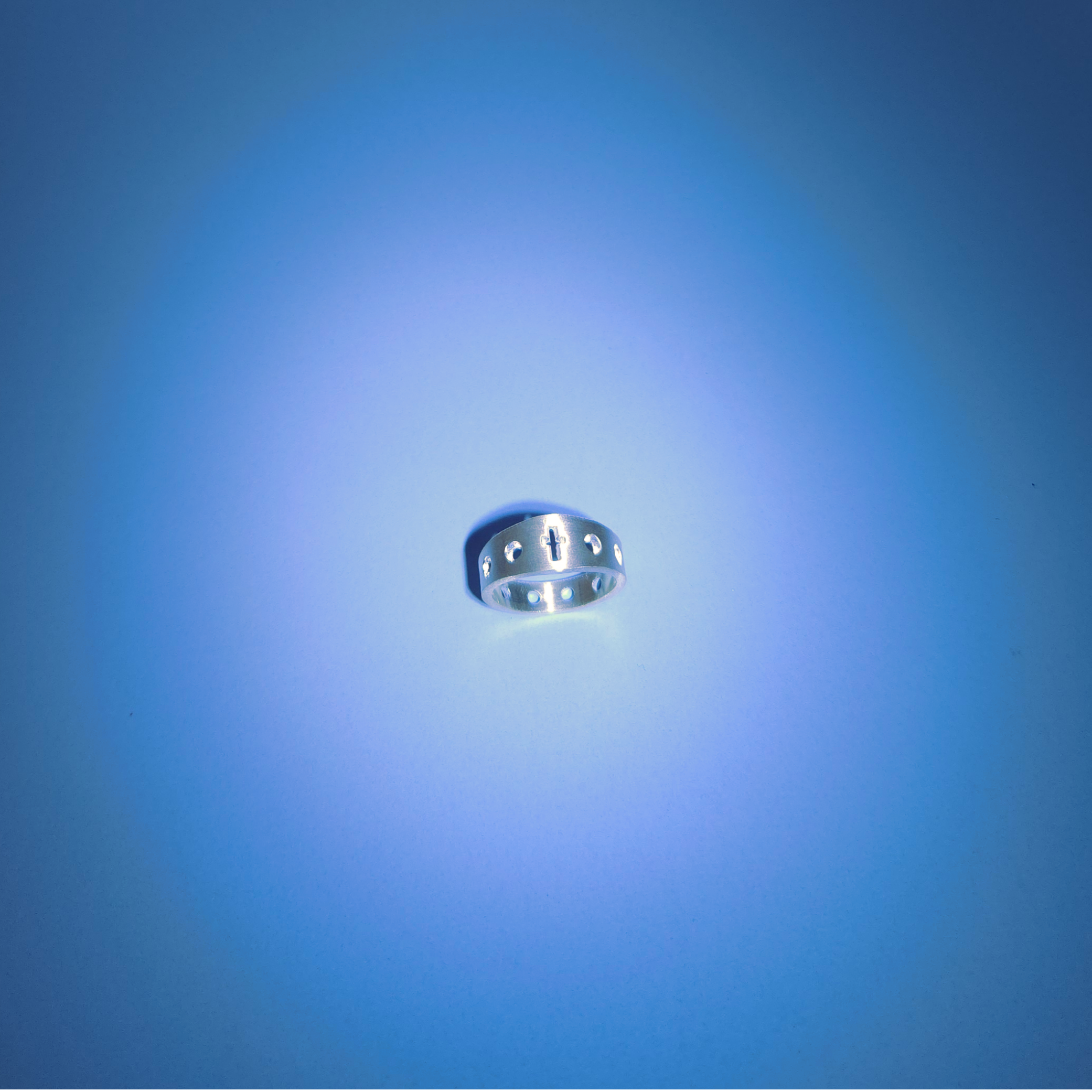 Silver rosary ring on a light blue background